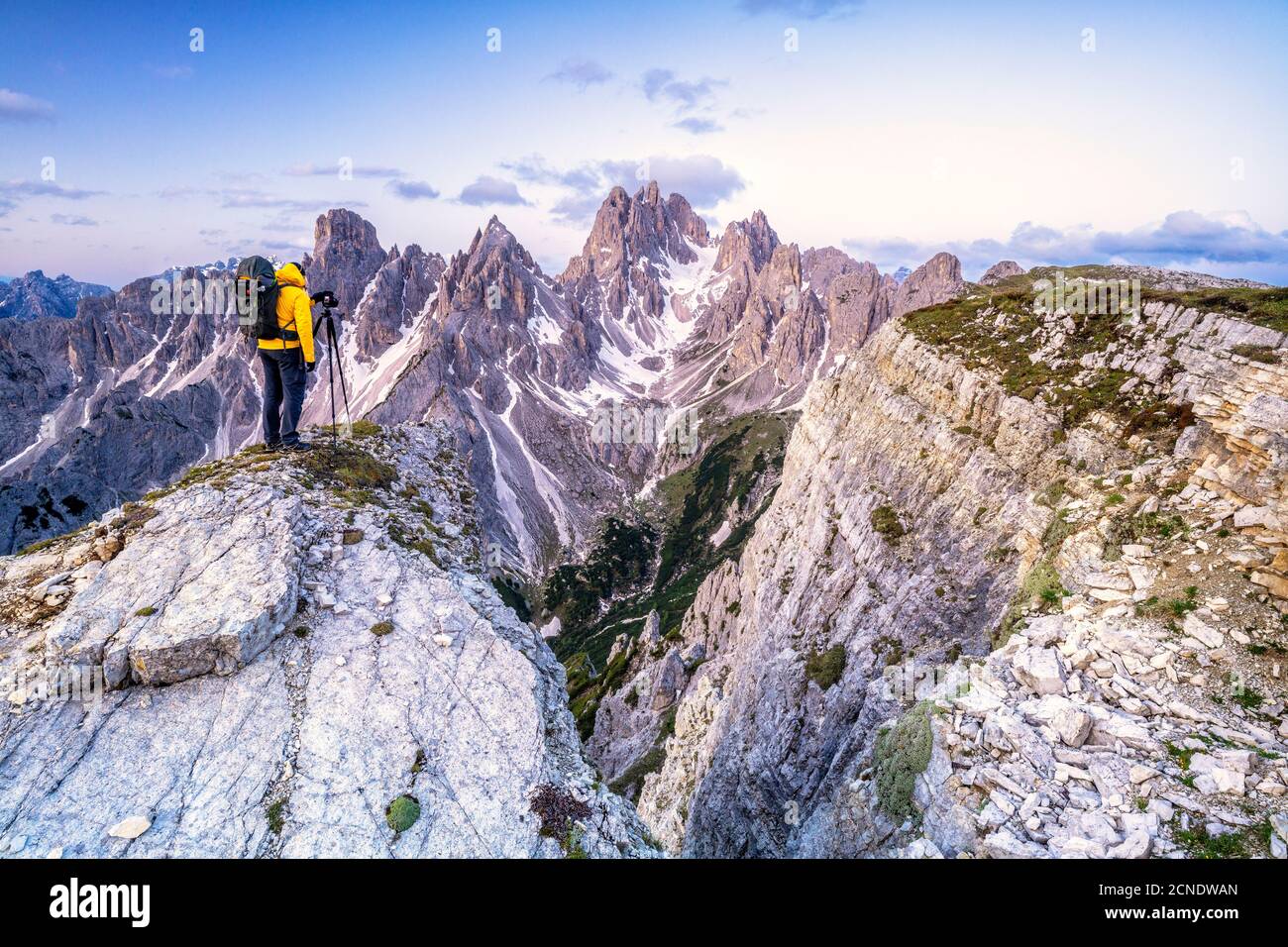 Man on top of rocks photographing Cadini di Misurina at sunrise, Dolomites, Belluno province, Veneto, Italy, Europe Stock Photo