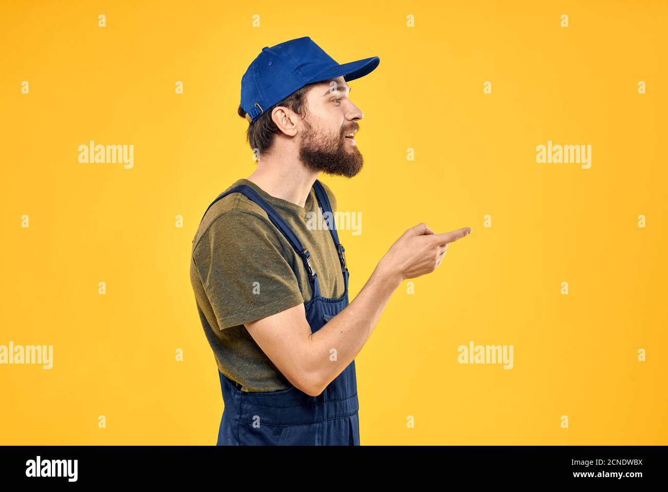 Worker man in uniform worker service yellow background emotion Stock