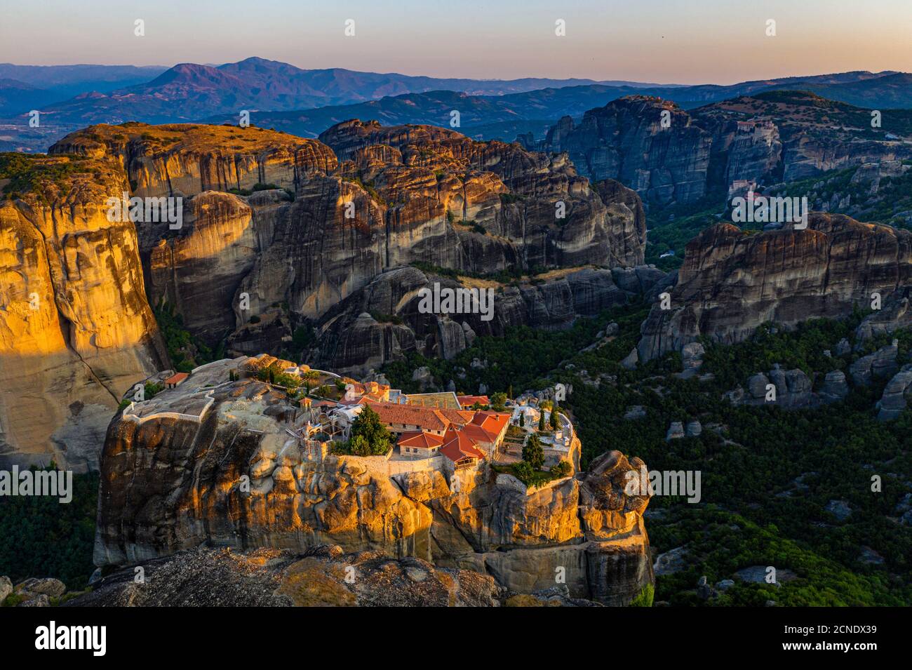Aerial by drone of the Holy Monastery of Holy Trinity at sunrise, UNESCO World Heritage Site, Meteora Monasteries, Greece, Europe Stock Photo