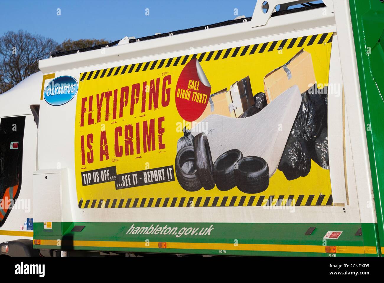 Flytipping is a crime poster on side of rubbish collection truck, lorry. UK Stock Photo