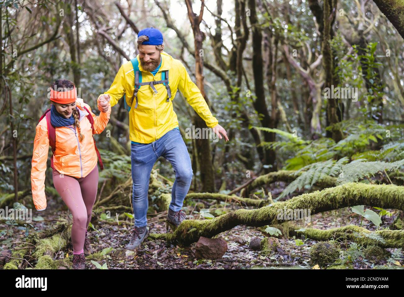 Young couple doing forest excursion - Happy people having fun discovering nature woods Stock Photo