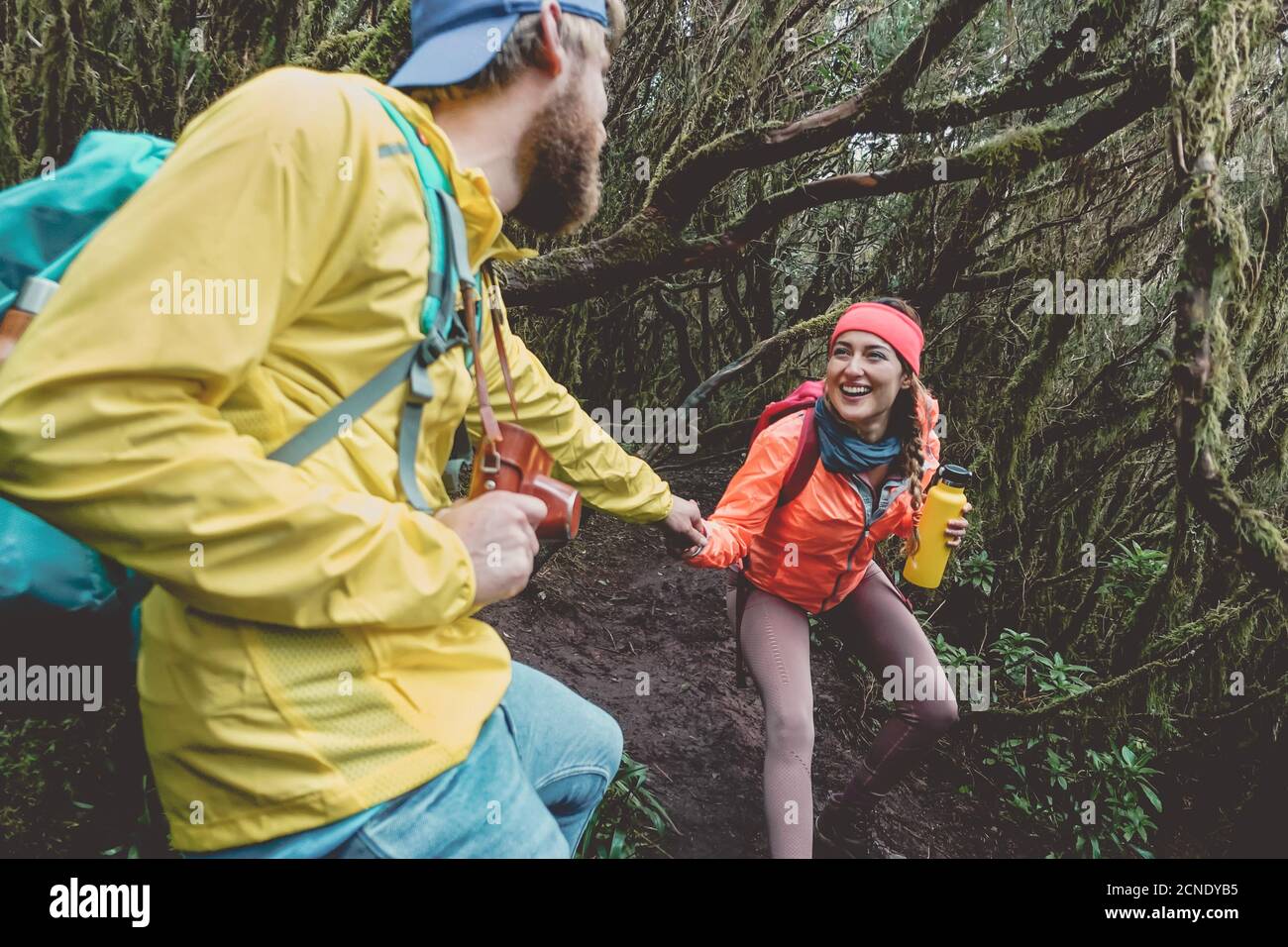 Young couple doing forest excursion - Happy people having fun discovering nature woods Stock Photo