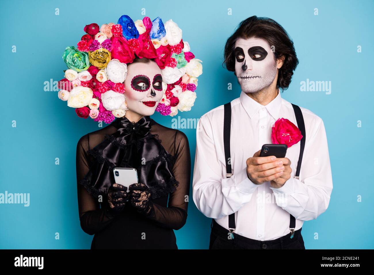 Photo of spooky two people man lady hold telephone look eye invited group monster chat wear black dress death costume sugar skull roses headband Stock Photo