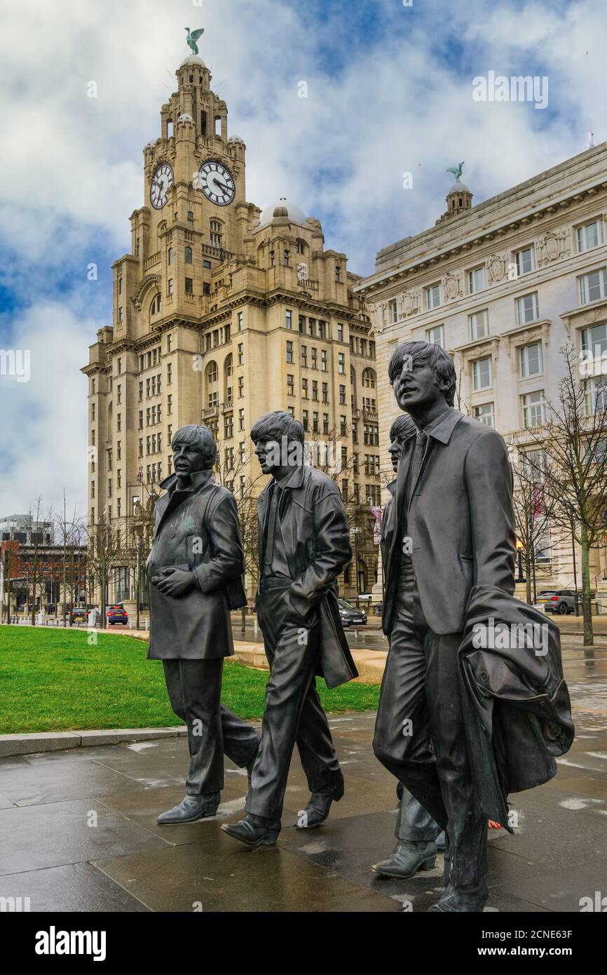The Beatles statue, bronze art depicting the famous band facing river Mersey with Royal Liver Building in the background, Liverpool, Merseyside, England Stock Photo