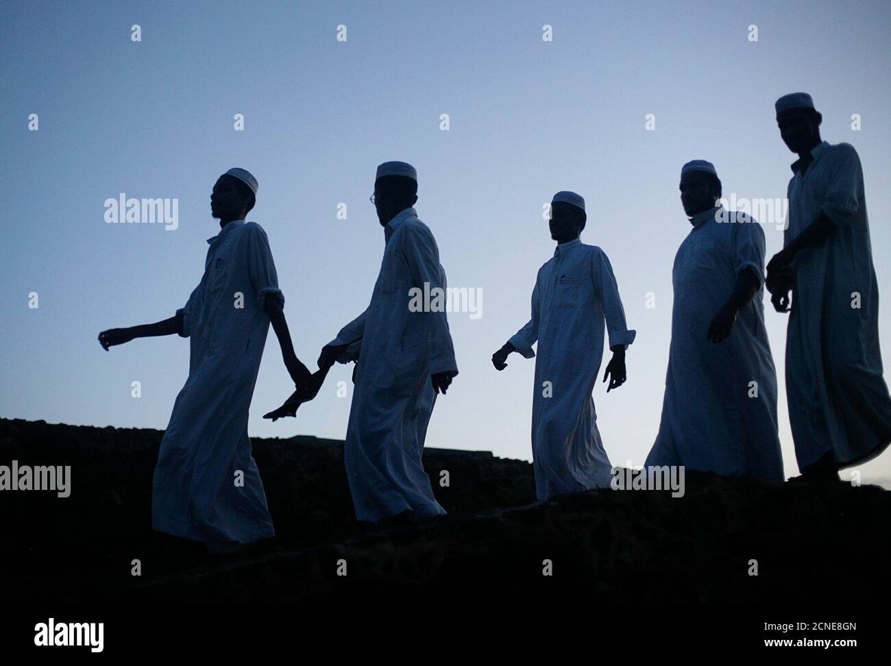Muslim men walk along the walls of the 16th century Dutch fort in Galle July 8, 2009.     REUTERS/Vivek Prakash (SRI LANKA RELIGION) Stock Photo