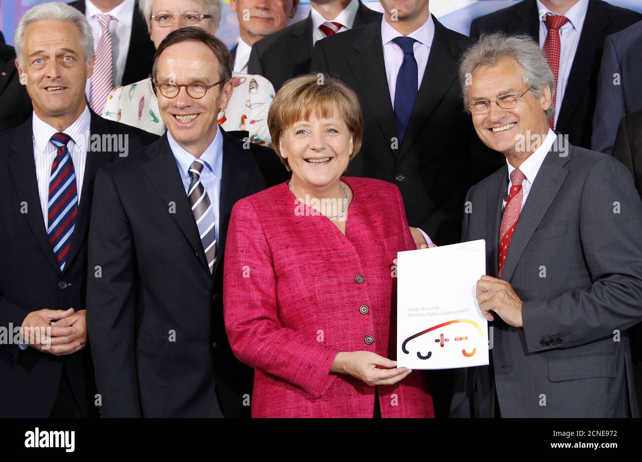 The head of the German Academy of Science Henning Kagermann (R) hands over the Second National Electromobility Report to German Chancellor Angela Merkel (2nd R) at the Chancellery in Berlin May 16, 2011.  Also pictured are the head of the German Automobile Industry Association (VDA) Mattias Wissmann (2nd L), Transport Minister Peter Ramsauer (L) .   REUTERS/Thomas Peter (GERMANY - Tags: POLITICS) Stock Photo