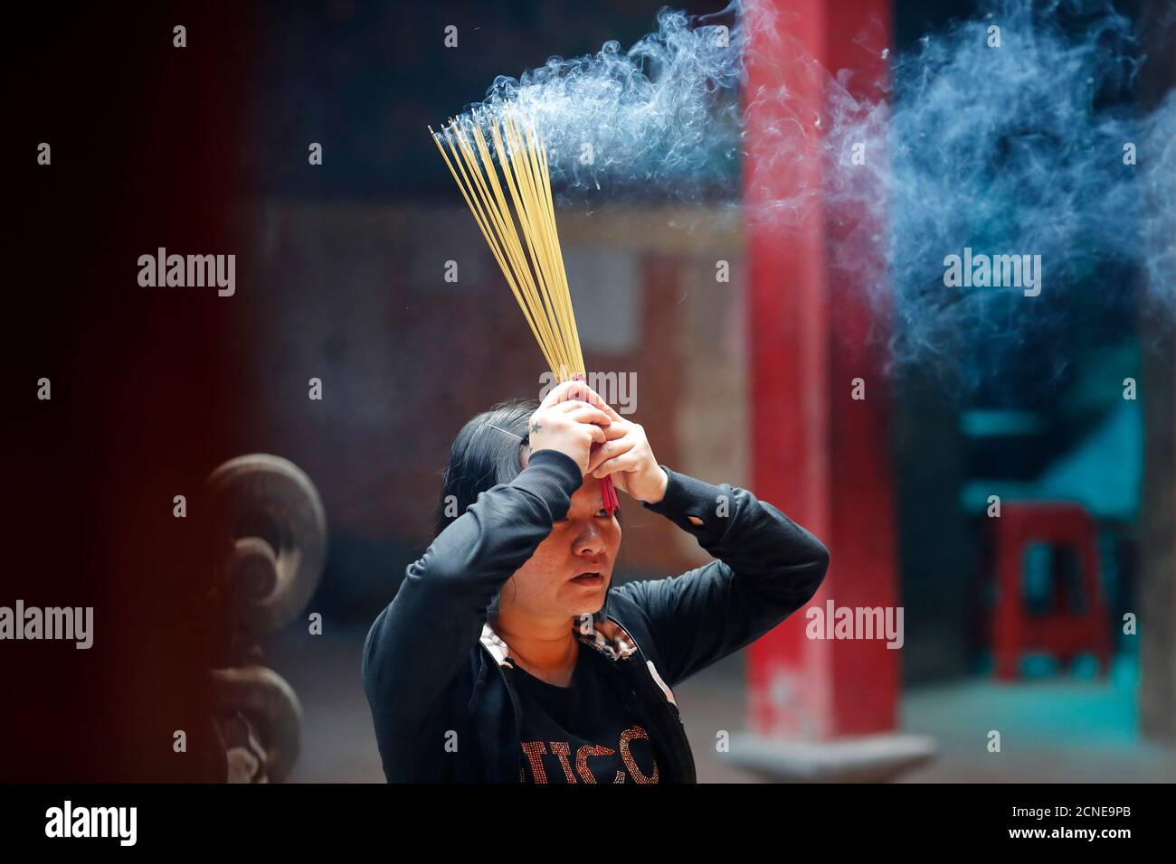 Taoist temple, Emperor Jade pagoda (Chua Phuoc Hai), Taoist worshipper burning incense sticks, Ho Chi Minh City, Vietnam, Indochina Stock Photo
