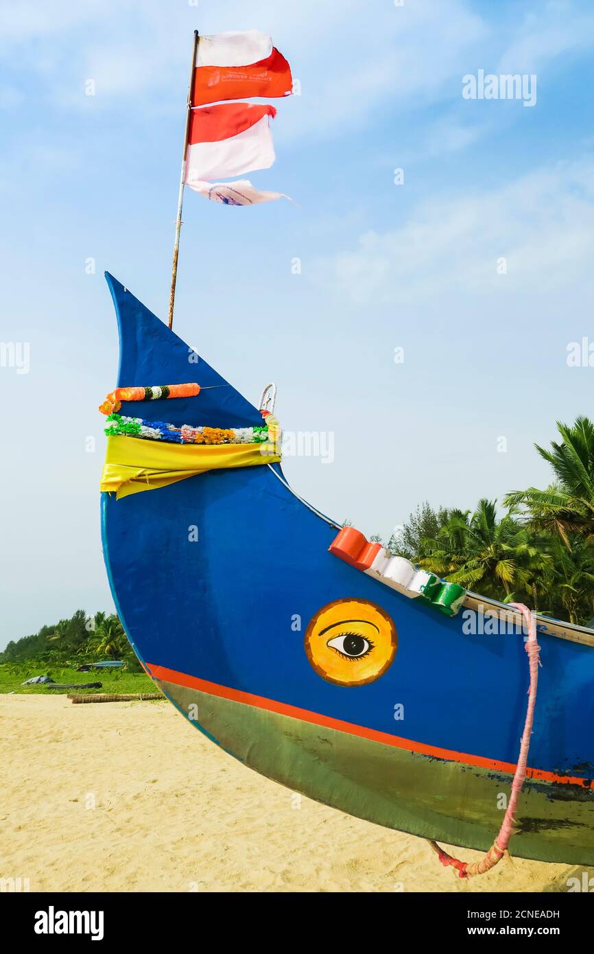 Colourful fishing boat with Indian flag and golden eye motifs on Marari Beach, Mararikulam, Alappuzha (Alleppey), Kerala, India, Asia Stock Photo