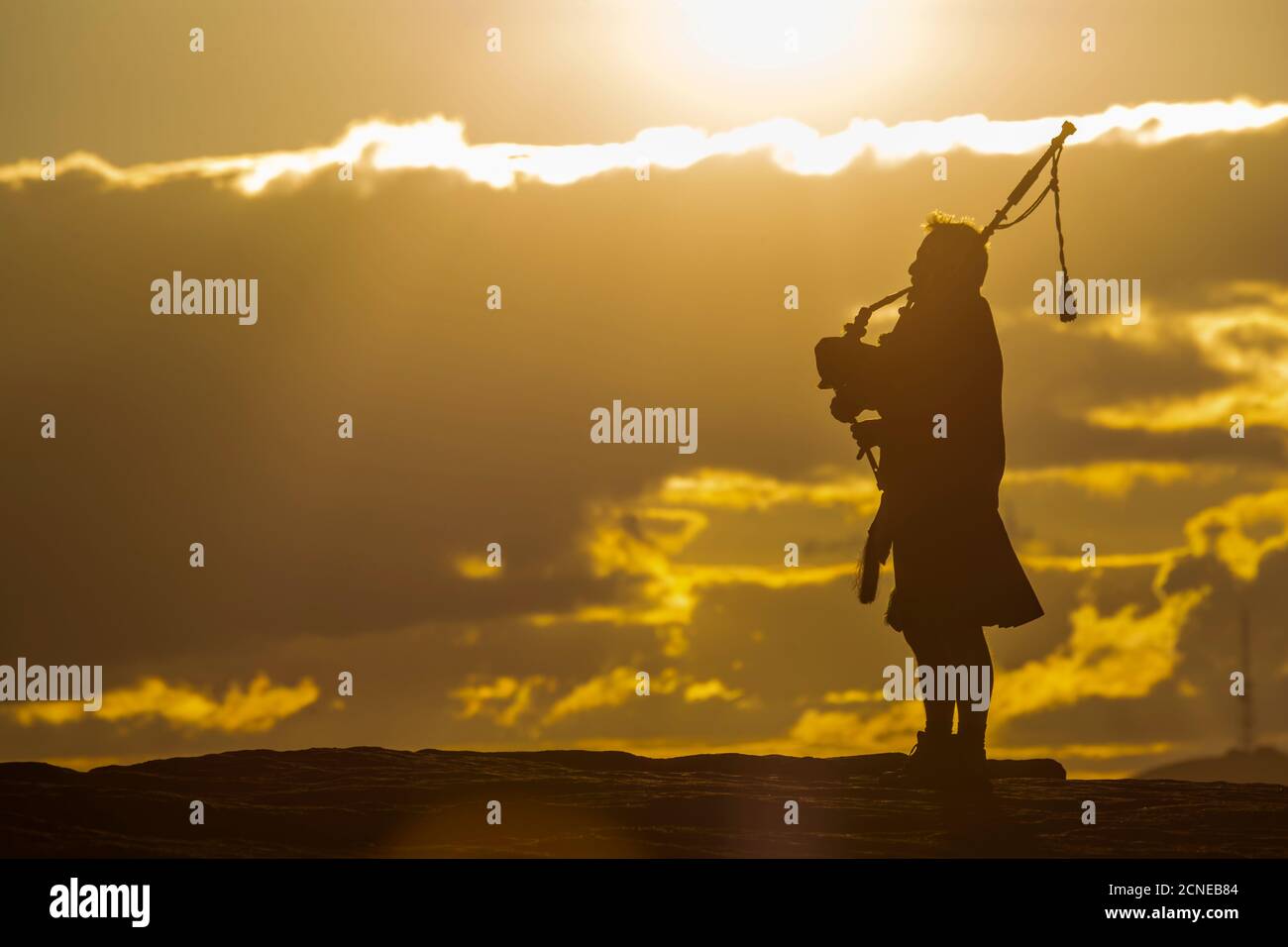View of lone piper at at sunset on Curbar Edge, Curbar, Hope Valley, Peak District National Park, Derbyshire, England, United Kingdom, Europe Stock Photo