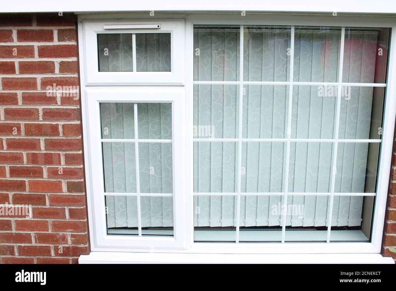 Georgian style UPVC double glazed window with built in ventilation above the small window UK Stock Photo