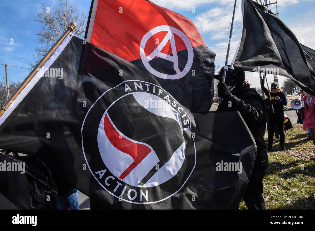 Members of the Great Lakes anti-fascist organization (Antifa) fly flags during a protest against the Alt-right outside a hotel in Warren, Michigan, U.S., March 4, 2018. REUTERS/Stephanie Keith Stock Photo