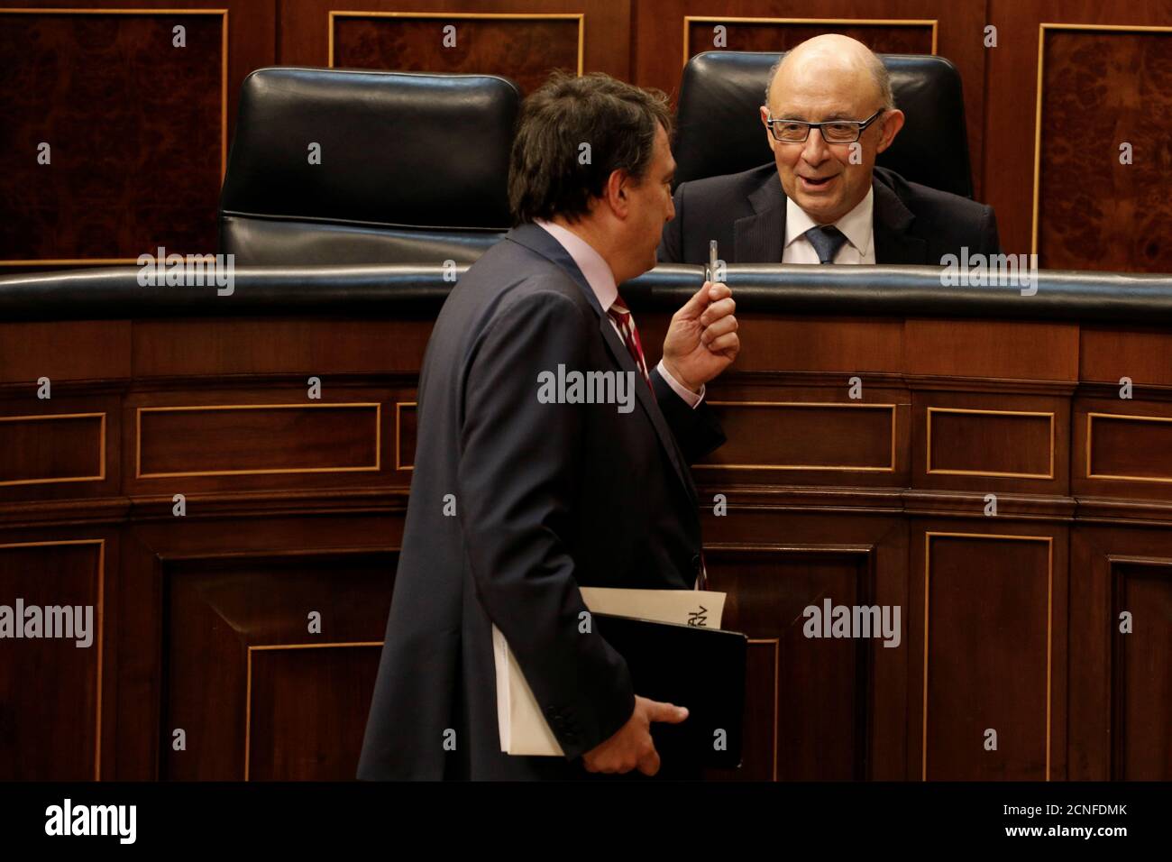Spain's Treasury Minister Cristobal Montoro talks to Aitor Esteban, spokesman of Basque Nationalist Party (PNV), during a 2018 budget plenary session at Parliament in Madrid, Spain, May 23, 2018. REUTERS/Paul Hanna Stock Photo