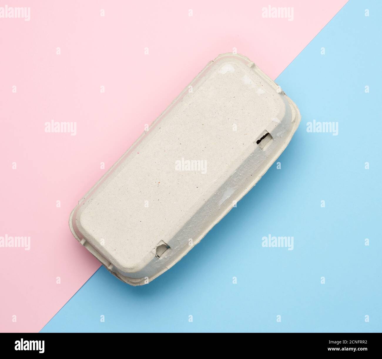 closed paper rectangular tray for chicken eggs on pink blue background, top view Stock Photo