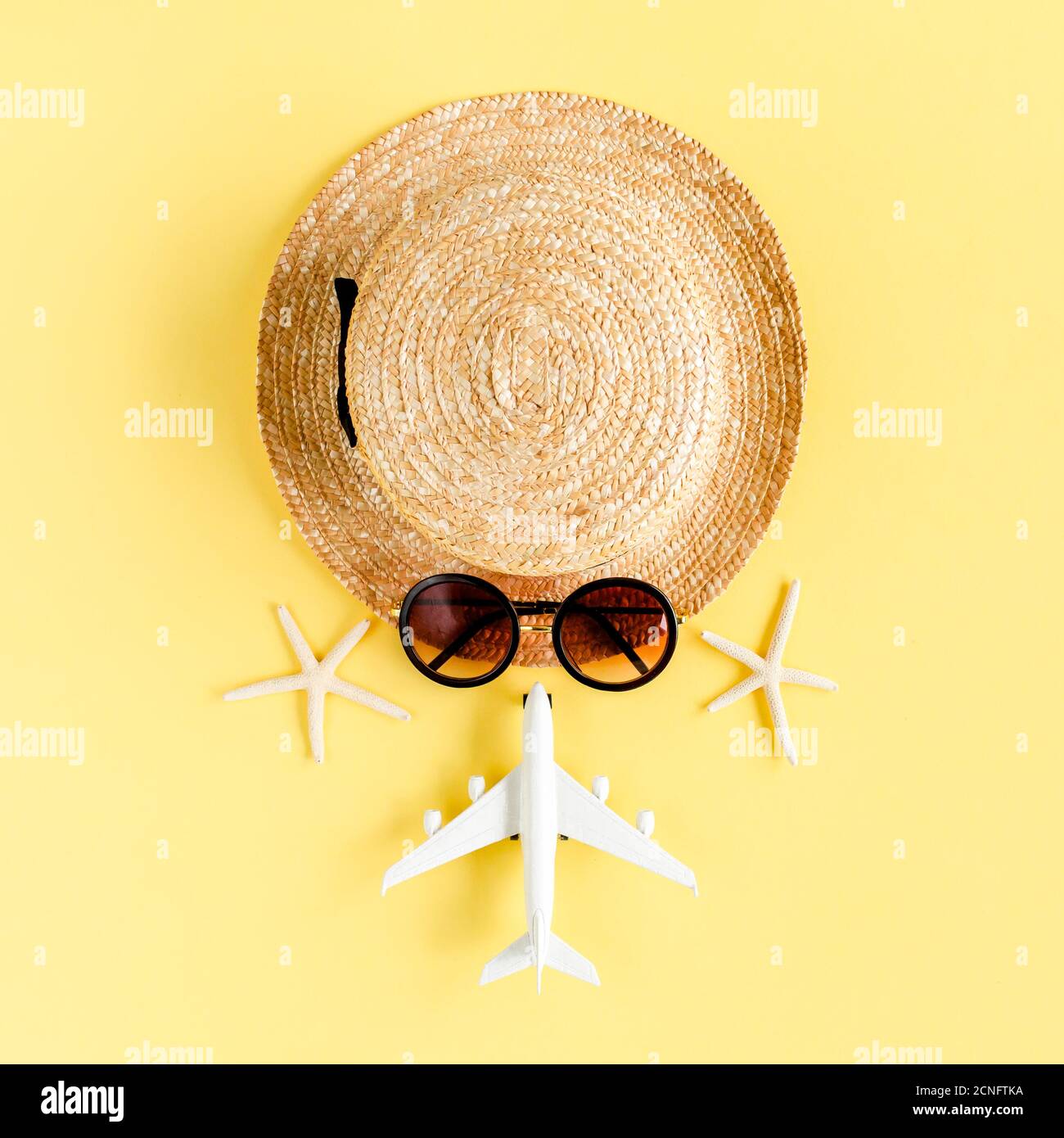 Tourist face made of straw hat, model plane, airplane and sunglasses on