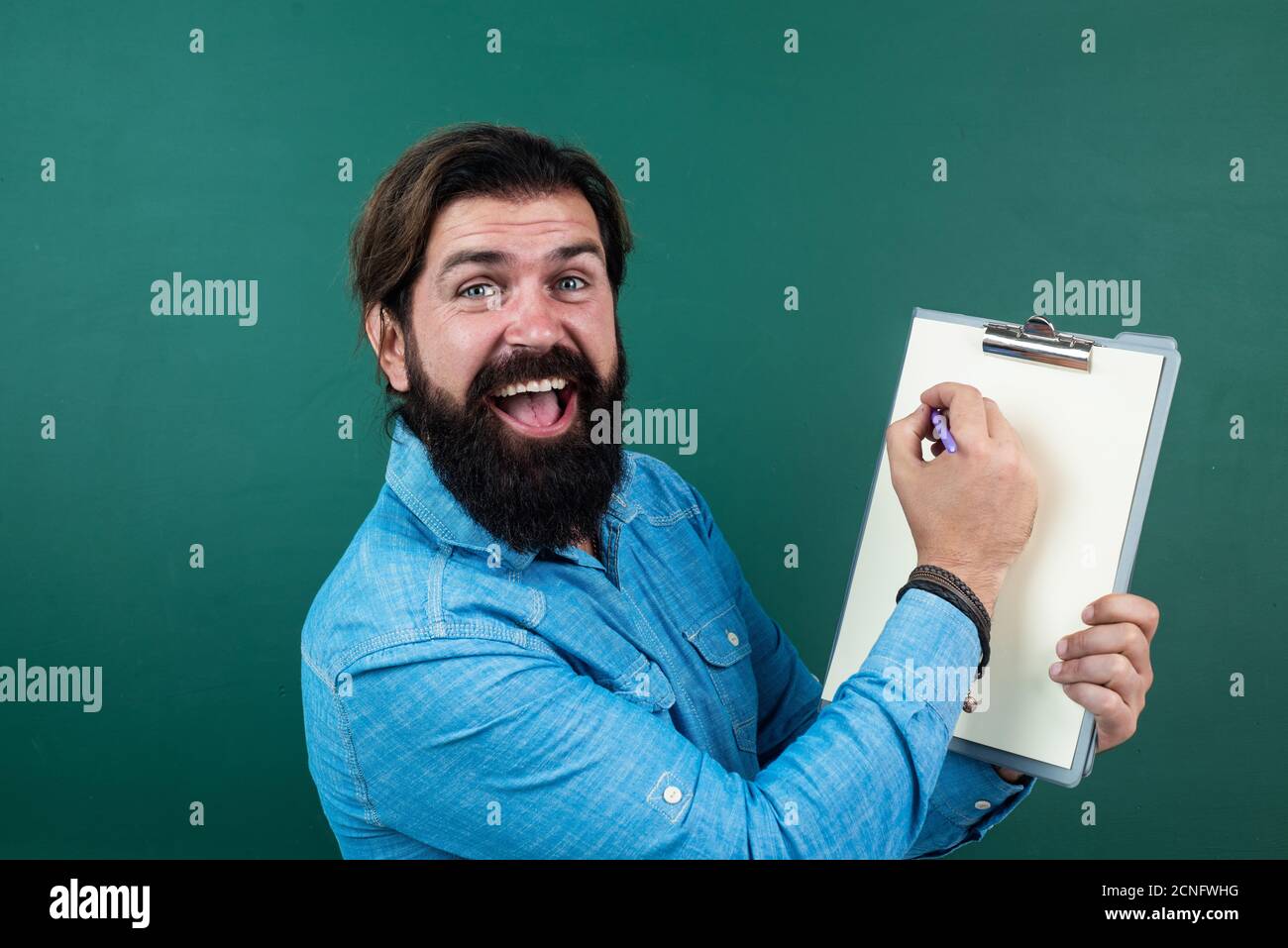 hun er Pudsigt bent good looking man with beard and moustache showing document paper for making  notes, copy space, project Stock Photo - Alamy