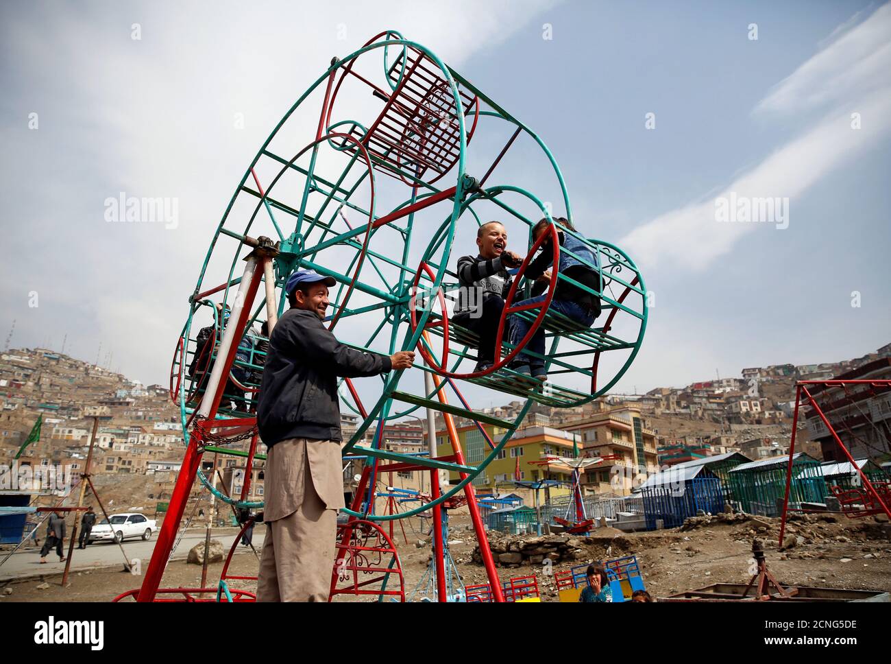 Children enjoy a manually operated ferris wheel in Kabul, Afghanistan March 20, 2018. REUTERS/Mohammad Ismail Stock Photo