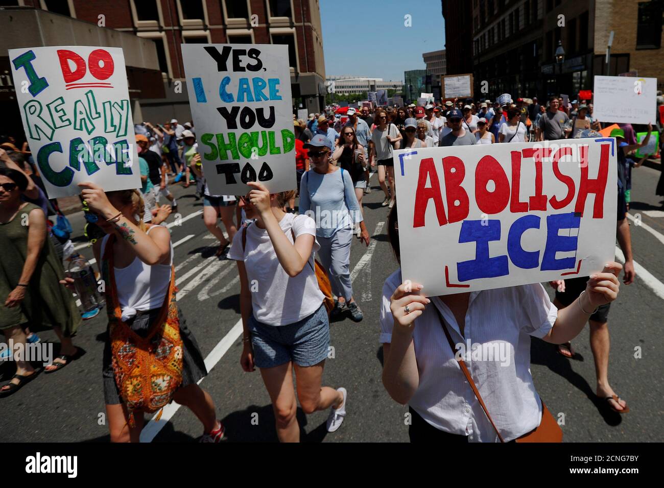 Demonstrators carrying signs reading 'Abolish ICE' and 'I Really Do Care', referencing the coat recently worn by First Lady Melania Trump, march during the 'Families Belong Together' rally in Boston, Massachusetts, U.S., June 30, 2018.   REUTERS/Brian Snyder Stock Photo