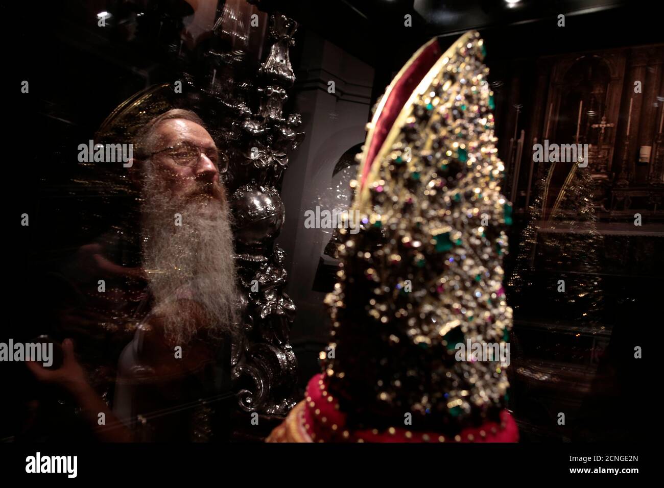 A visitor looks at the Mitre of San Gennaro during an exhibition in Rome October 29, 2013. One of the world's richest treasure troves went on display in Rome on Tuesday, including gem-studded chalices, sumptuous jewellery and golden trinkets collected over seven centuries. It was the first time such a large selection of the 'Treasure of San Gennaro', precious objects donated in tributes to the patron saint of Naples, has been displayed outside of the southern Italian city.   REUTERS/Tony Gentile (ITALY - Tags: SOCIETY) Stock Photo
