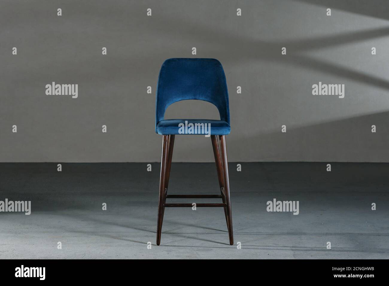 Blue dining room chair in a studio with gray walls Stock Photo Alamy