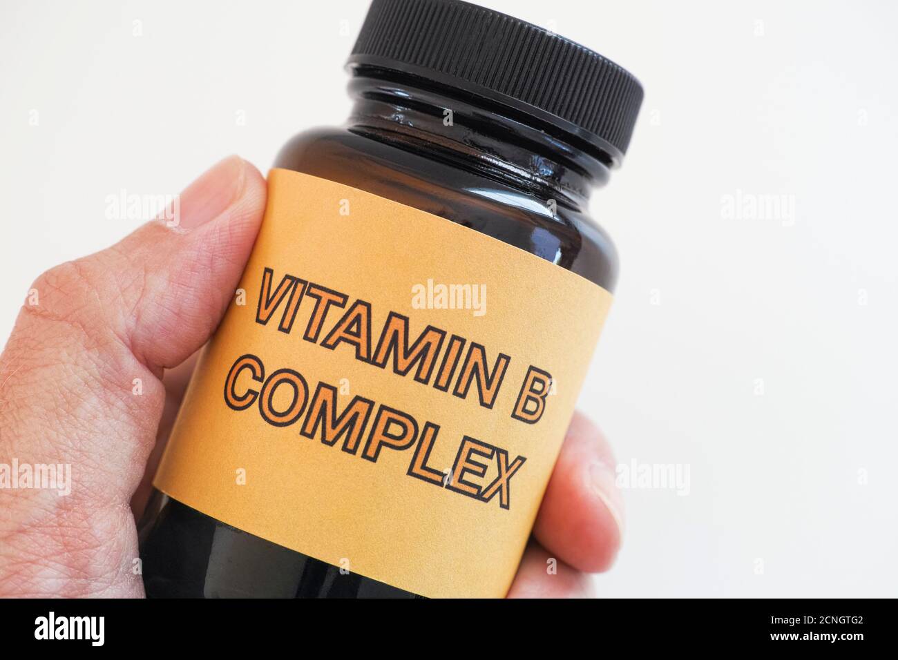 Person holding a bottle of Vitamin B Complex. Close up. Stock Photo