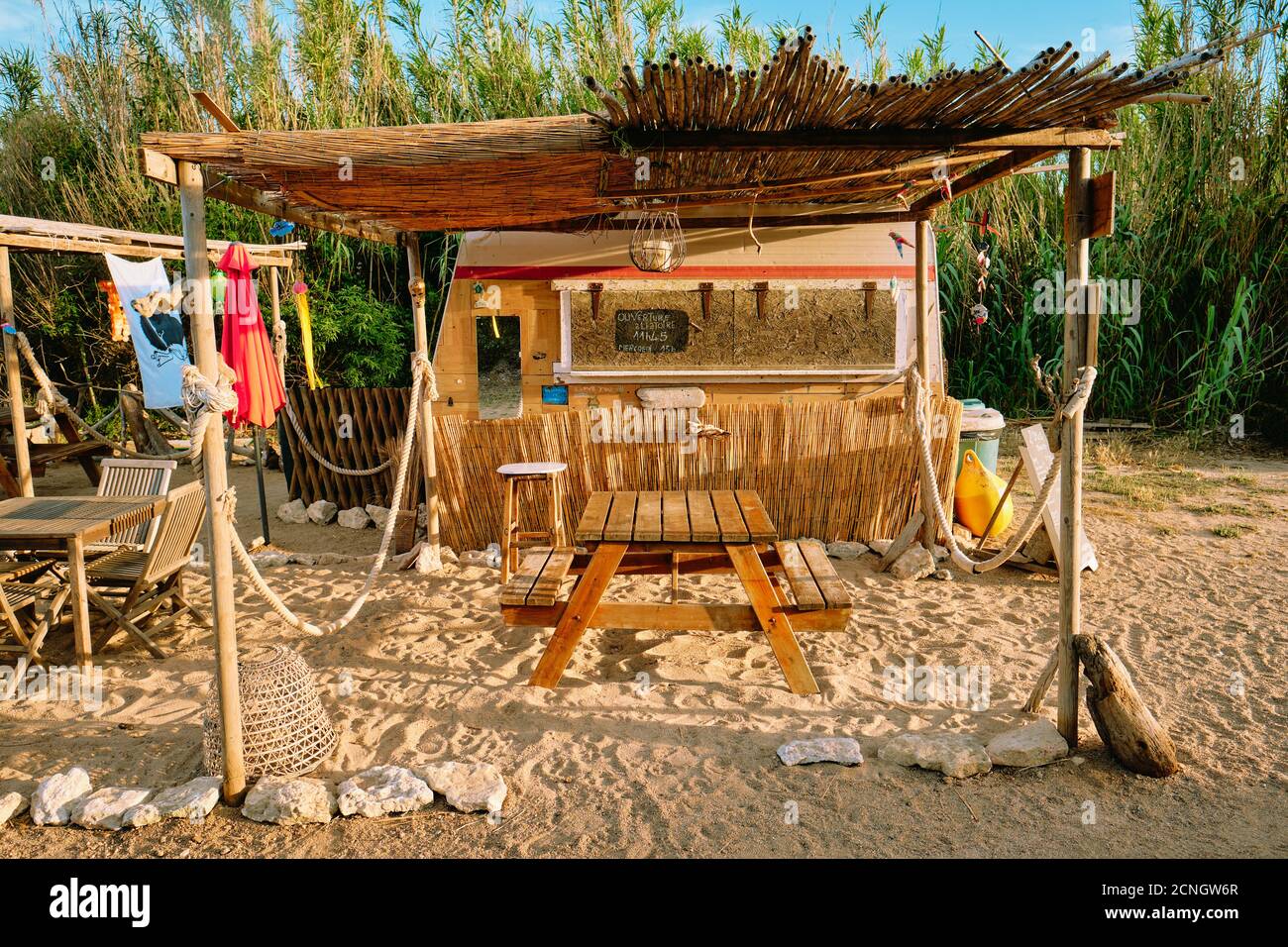 A rustic summer beach bar cafe shack / cabana made from recycled reclaimed materials in Corsica France - Corsica beach cafe. Stock Photo