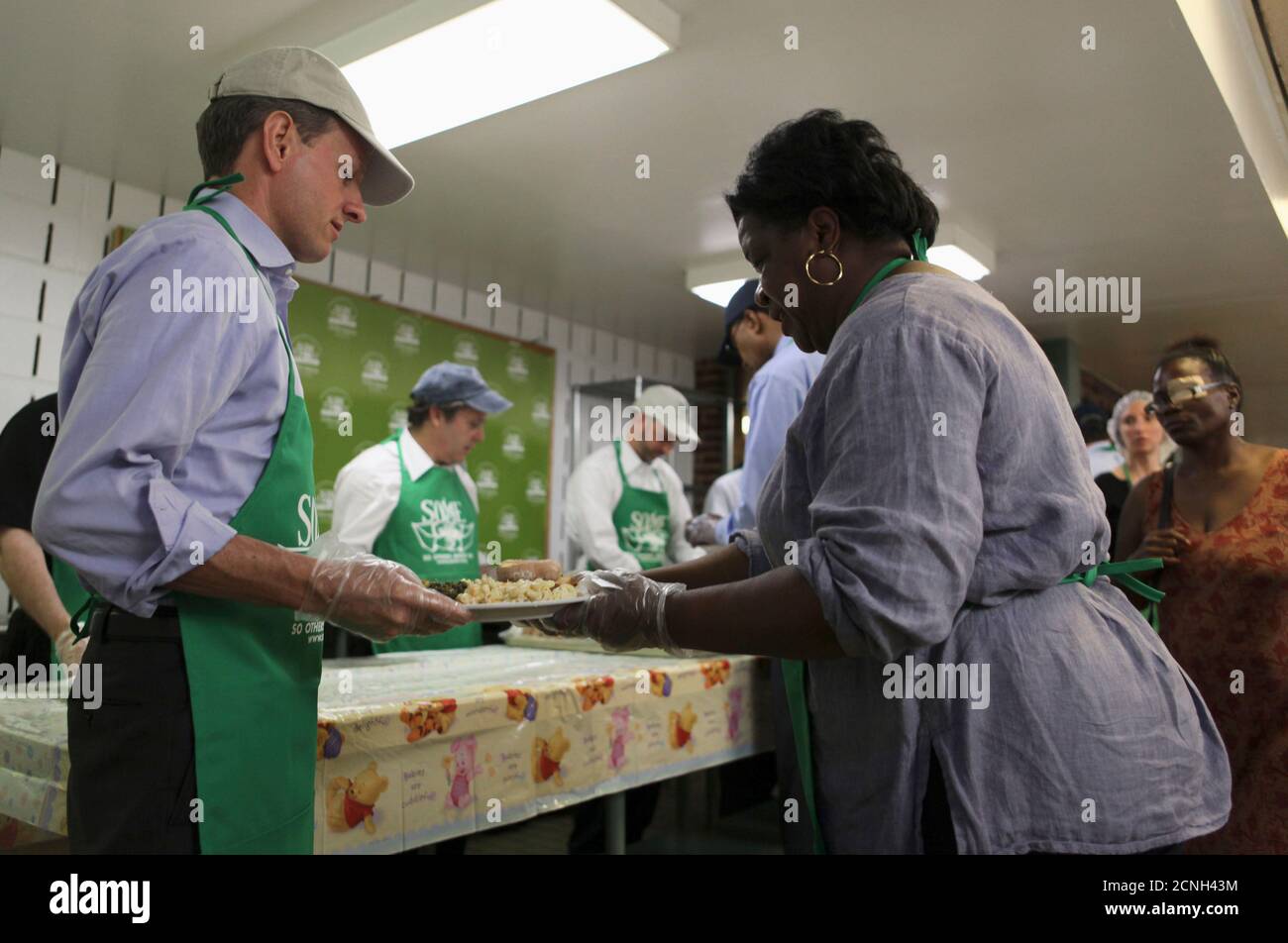 U.S. Treasury Secretary Timothy Geithner serves lunch to the homeless and other clients at the 'So Others May Eat'  (SOME) soup kitchen and social service center for the poor in downtown Washington, June 25, 2009.    REUTERS/Jim Bourg  (UNITED STATES POLITICS) Stock Photo
