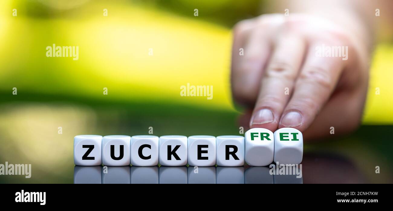 Hand turns dice and changes the German expression 'Zucker' (sugar) to 'Zucker frei' (sugar free). Stock Photo