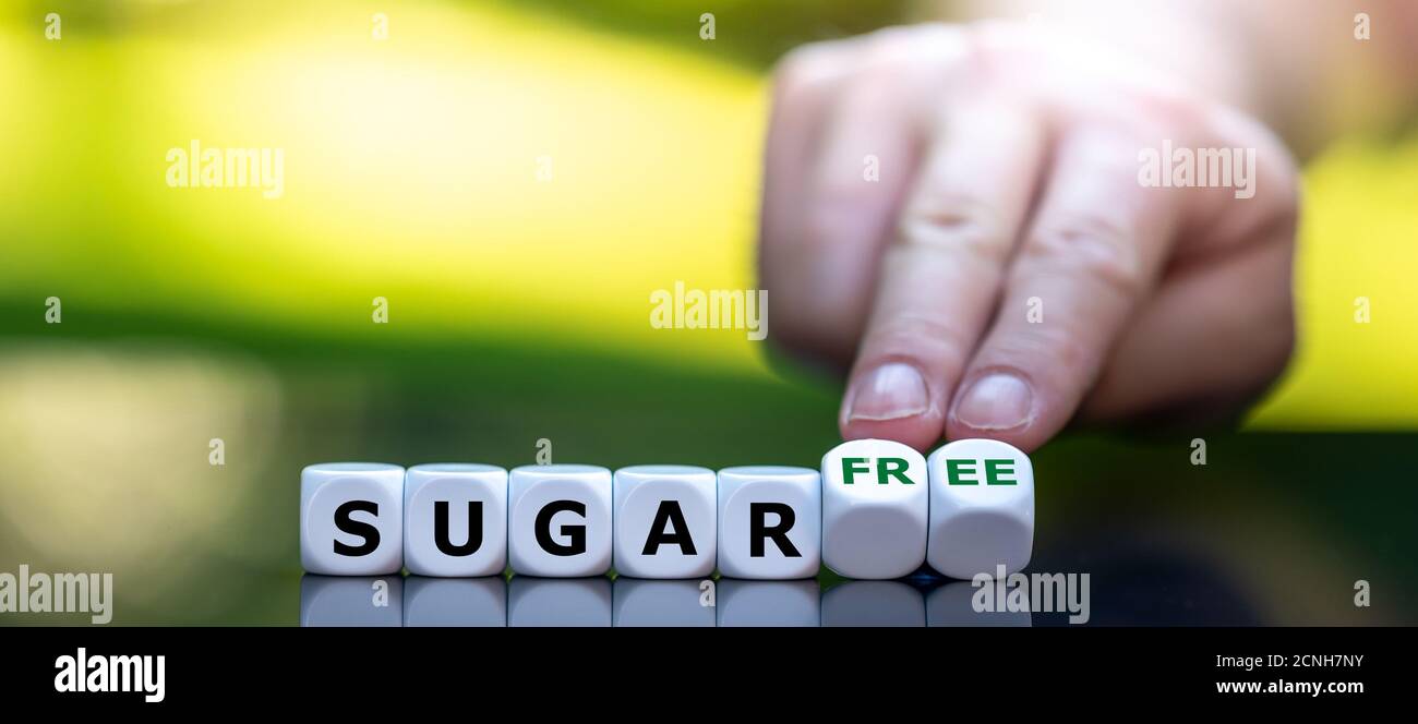 Hand turns dice and changes the expression 'sugar' to 'sugar free'. Stock Photo