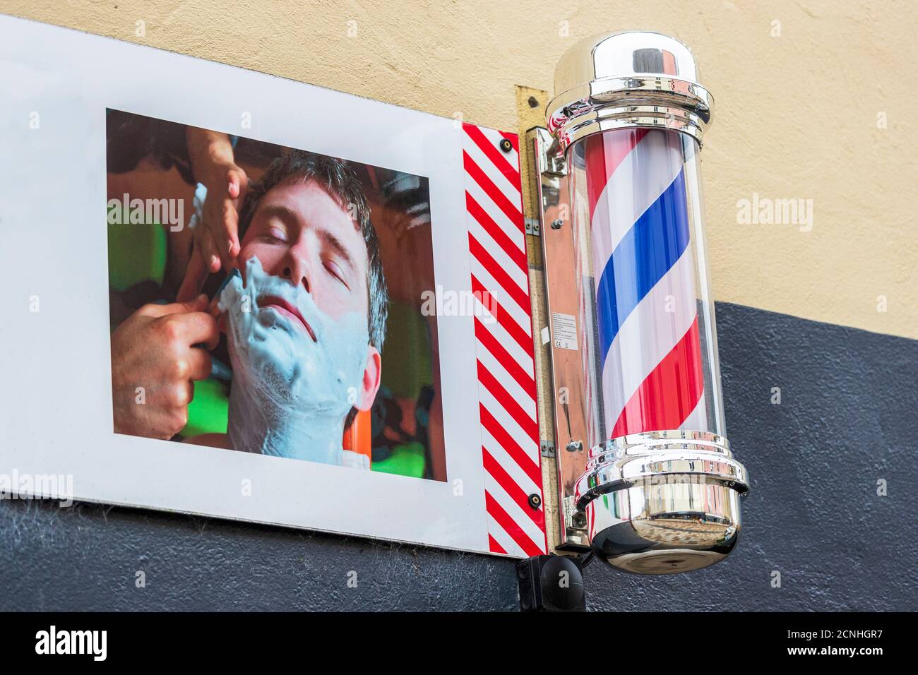 Traditional red, white and blue barber's sign pole outside a gents