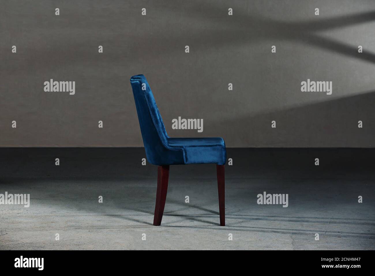 Blue dining room chair in a studio with gray walls Stock Photo Alamy