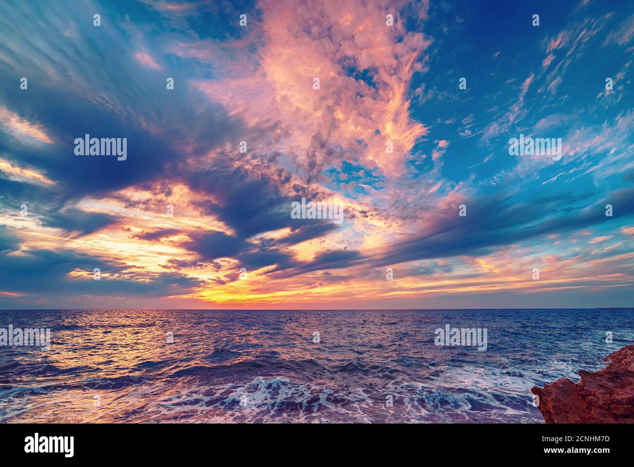 Beautiful colorful sunset at the sea with dramatic clouds and colorful ...