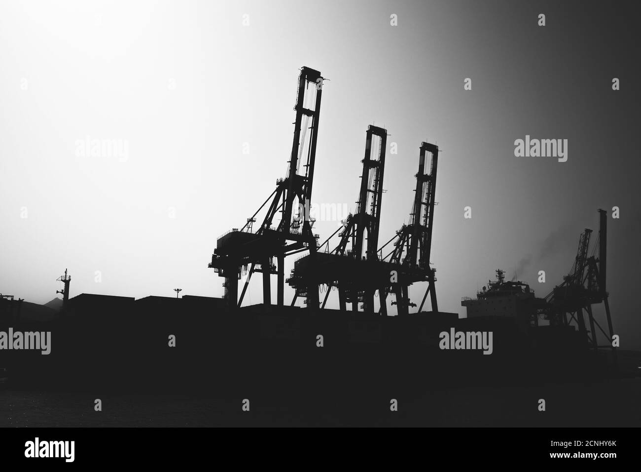 Gantry cranes silhouette photo, industrial cargo port view, black and white Stock Photo