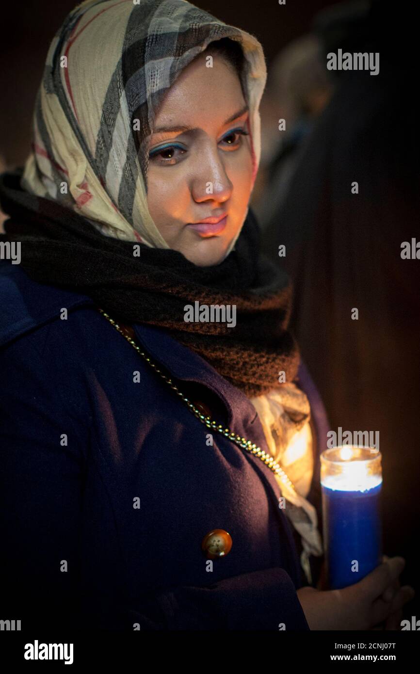 A woman holds a candle during a vigil, for victims killed during the attack in Peshawar Pakistan, in the Brooklyn borough of New York December 17, 2014. Pakistan on Wednesday began burying 132 students killed in a grisly attack on their school by Taliban militants that has heaped pressure on the government to do more to tackle an increasingly aggressive Taliban insurgency. REUTERS/Brendan McDermid (UNITED STATES - Tags: CRIME LAW SOCIETY CIVIL UNREST EDUCATION) Stock Photo