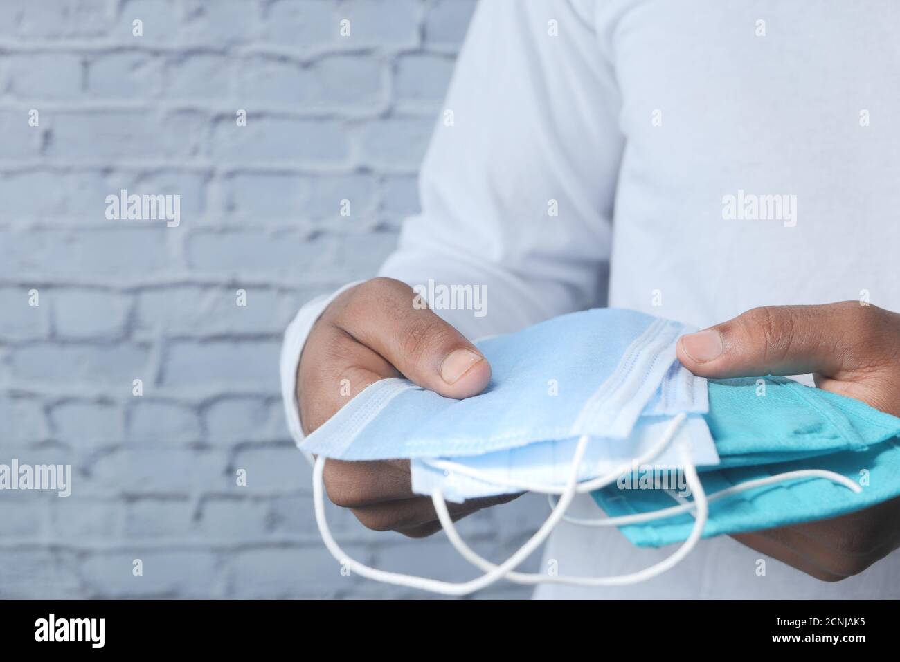 man hand holding surgical face mask, close up Stock Photo