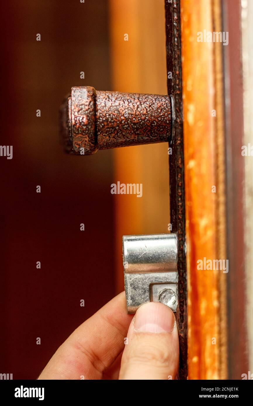 Locksmith installs new door lock into wooden door Stock Photo Alamy