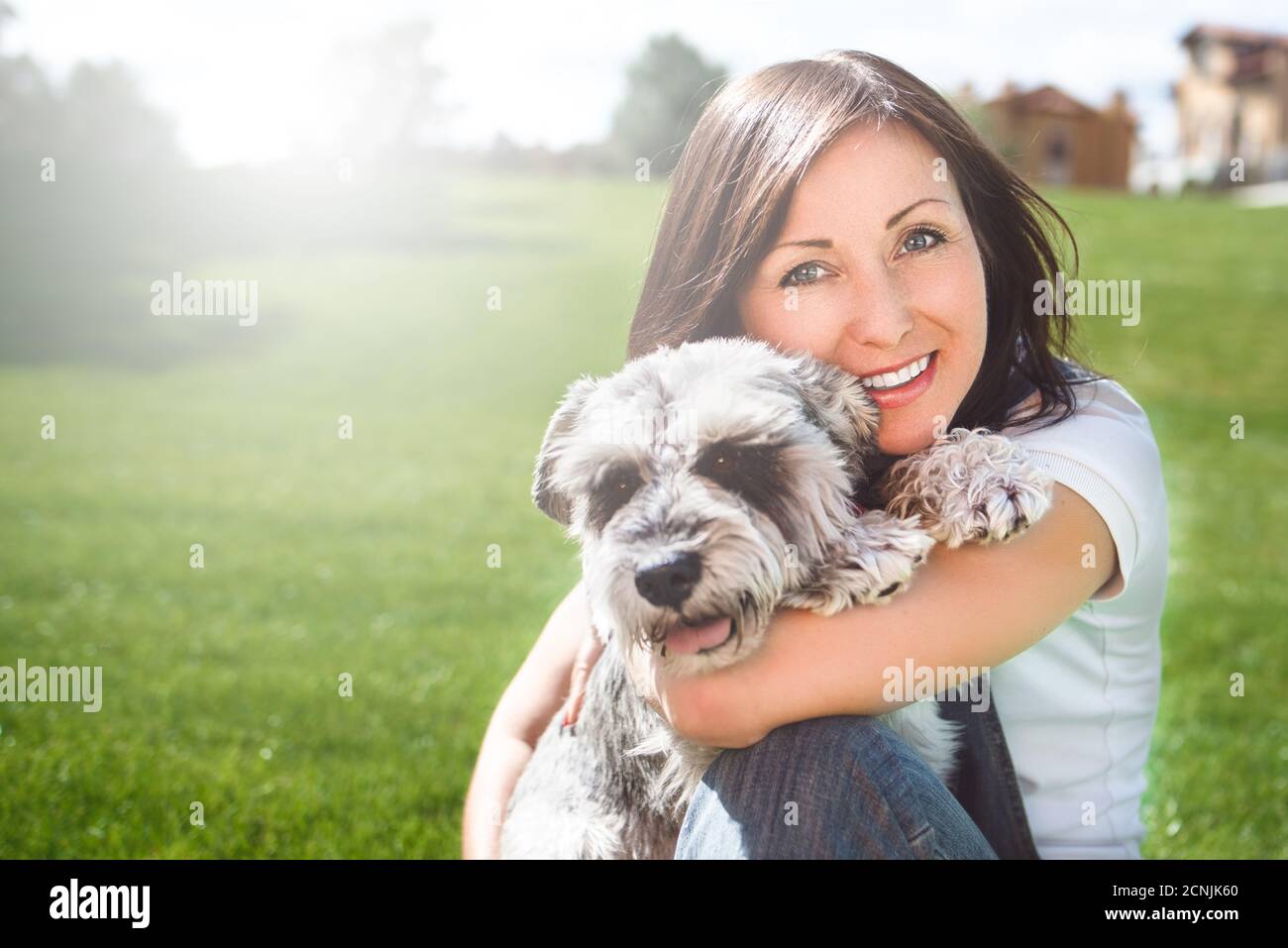 Portrait of a happy caucasian woman who hugs her beloved dog.The concept of love for animals. best friends. Dog breed Schnauzer Stock Photo