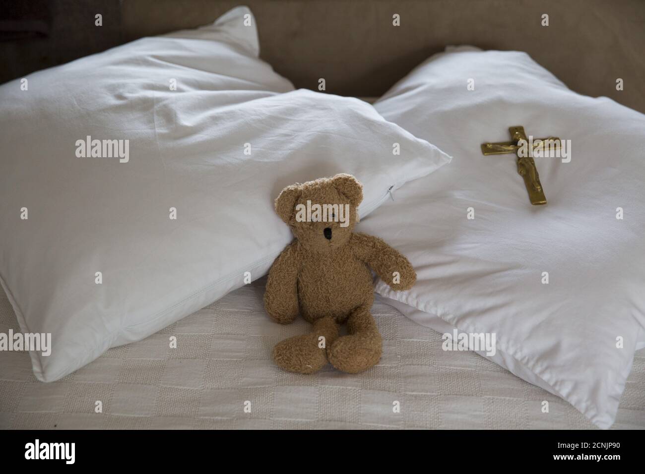 A teddy bear and cross lie on the bed of Sister Rachel Denton at St Cuthbert's Hermitage in Lincolnshire, north east Britain August 24, 2015. Denton, a Catholic hermit, rises early to tend to her vegetable garden, feed her cats and pray. But the former Carmelite nun, who in 2006 pledged to live the rest of her life in solitude, has another chore - to update her Twitter account and check Facebook. 'The myth you often face as a hermit is that you should have a beard and live in a cave. None of which is me,' says the ex-teacher. For the modern-day hermit, she says social media is vital: 'tweets a Stock Photo