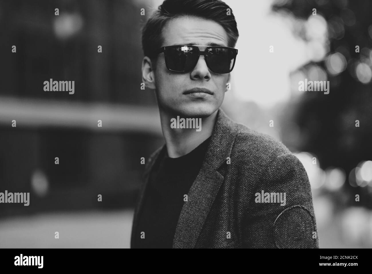 Serious cool guy with sunglasses walking at street. Stock Photo