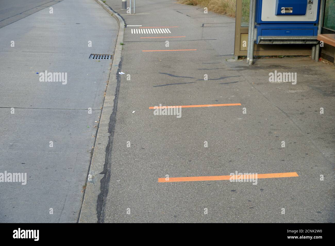 Bus stop with lines on the ground for keeping a safe distance between the passengers as measure of preventing spreading of corona virus and covid-19. Stock Photo