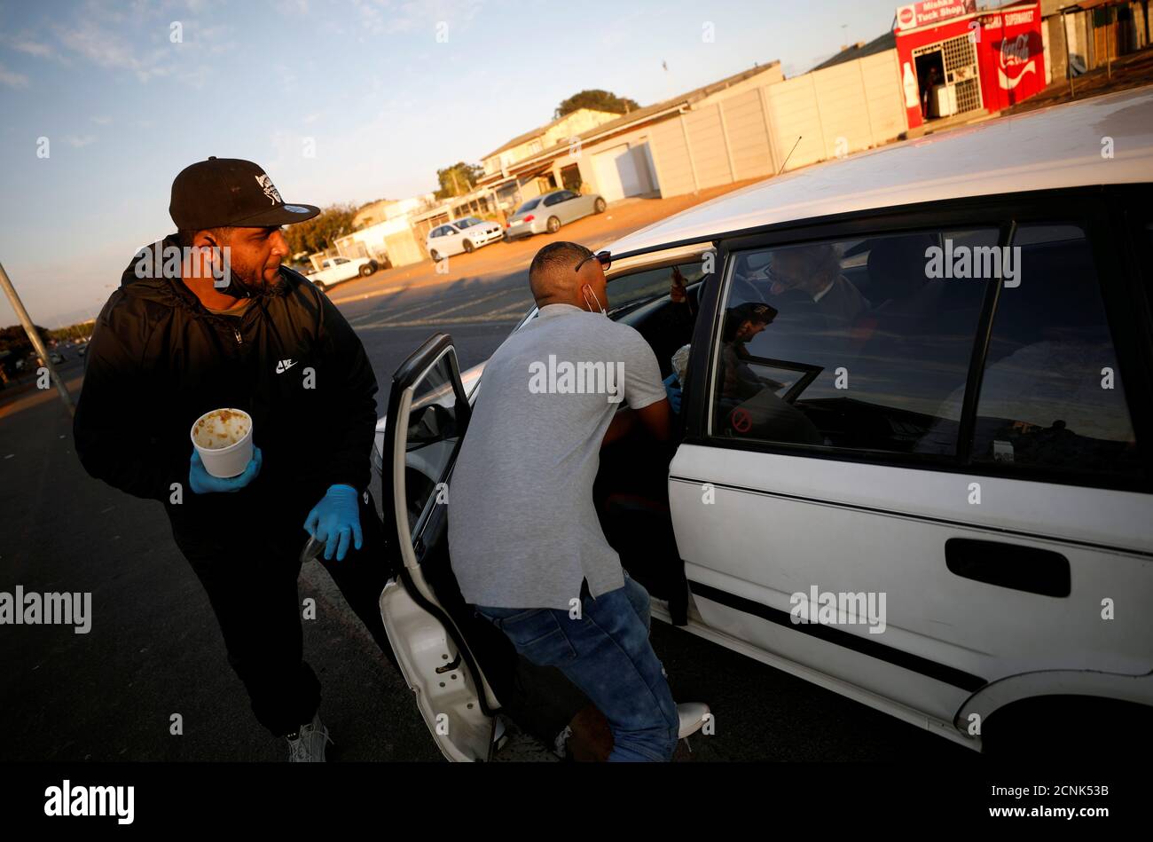 A group of barbers whose shops remain closed under the coronavirus disease (COVID-19) lockdown regulations, distribute food to residents in Bonteheuwel township in Cape Town, South Africa, June 7, 2020. Picture taken  June 7, 2020. REUTERS/Mike Hutchings Stock Photo