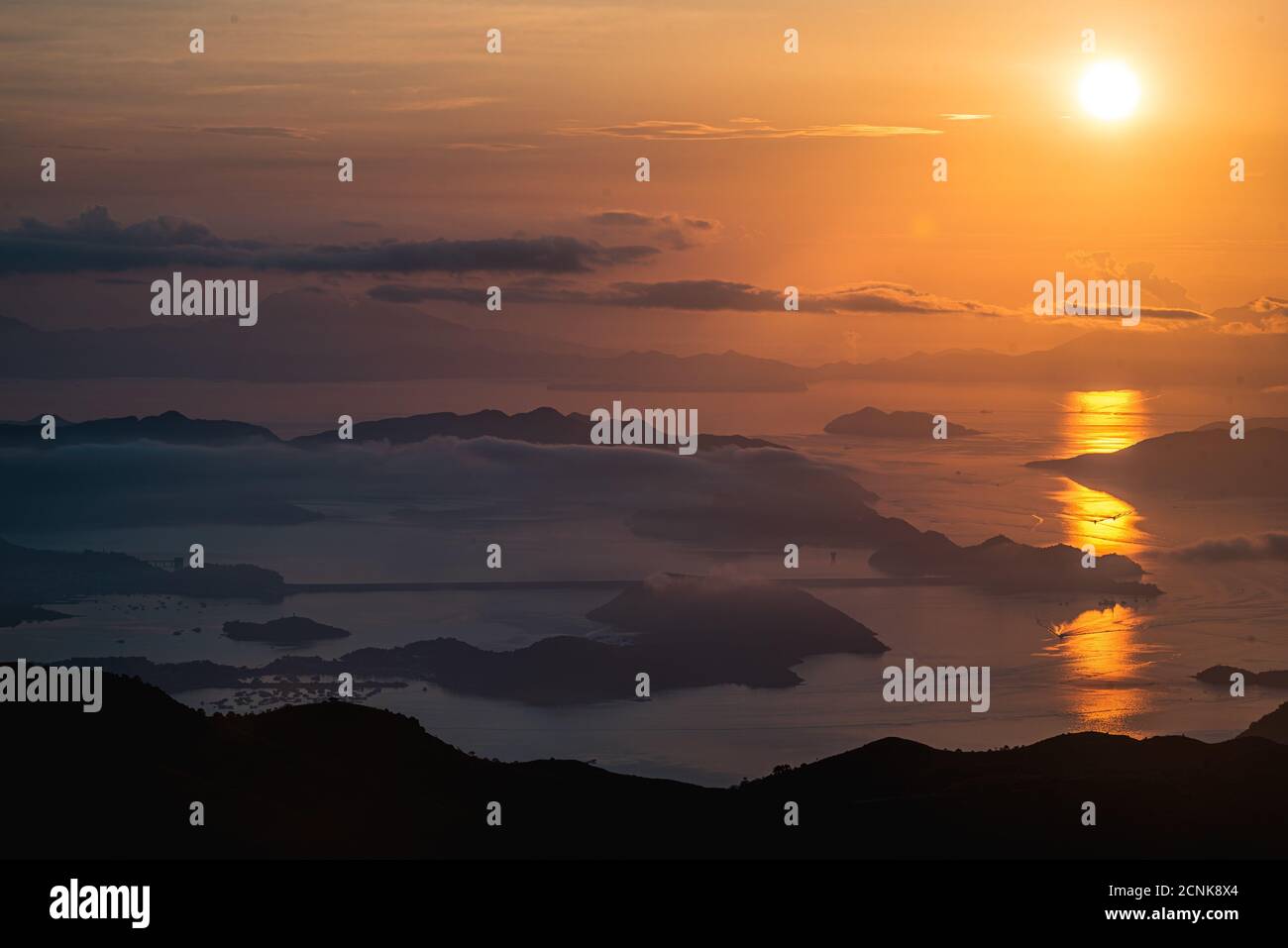 A breathtaking view of the golden sunset over the sea and the hills ...