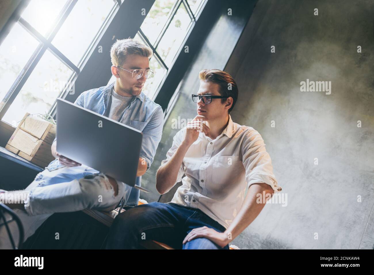 Two business colleagues sitting at a table, having a meeting. Stock Photo