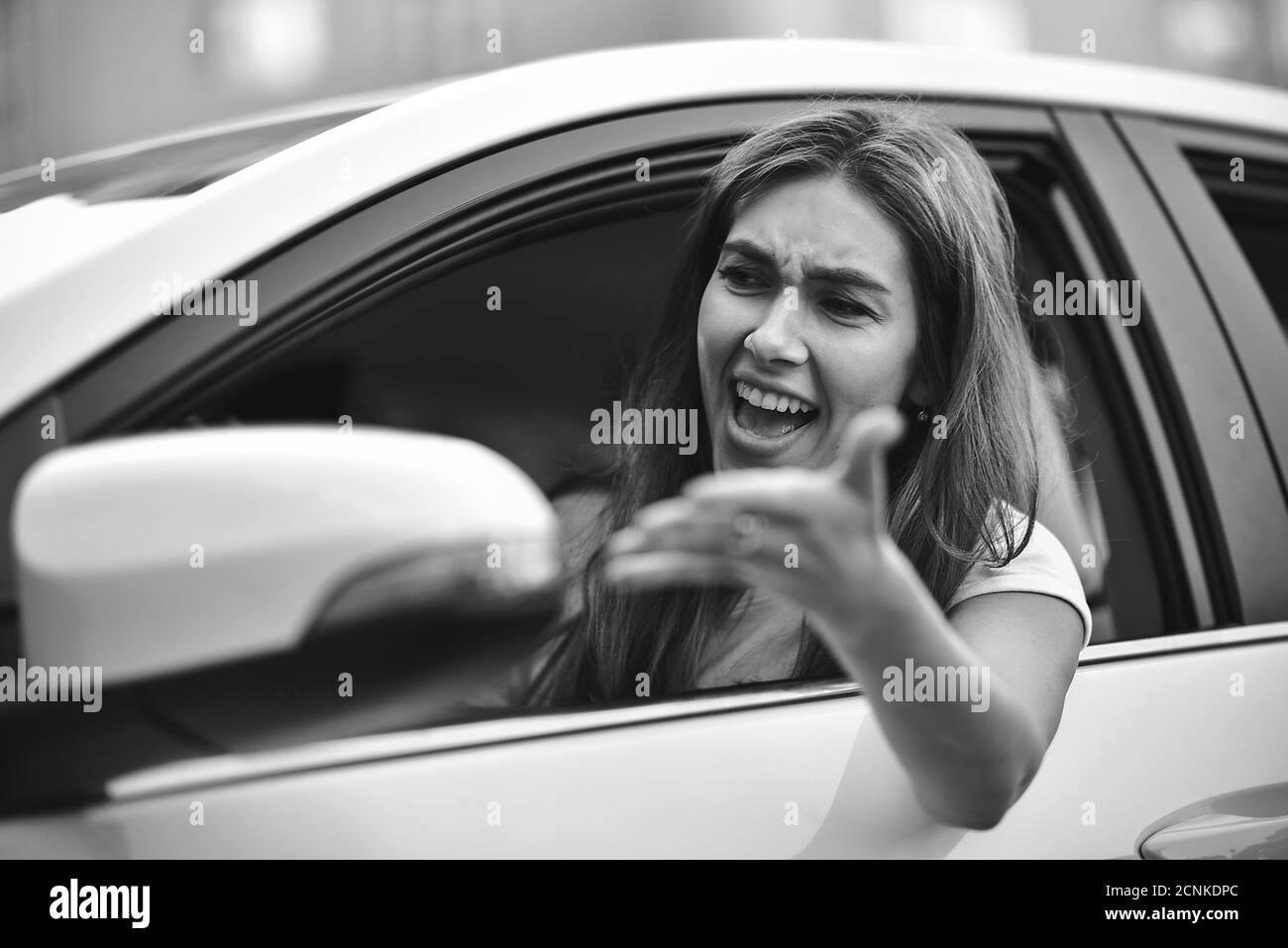 Young girl driving a car shocked about to have traffic accident, windshield view. Stock Photo