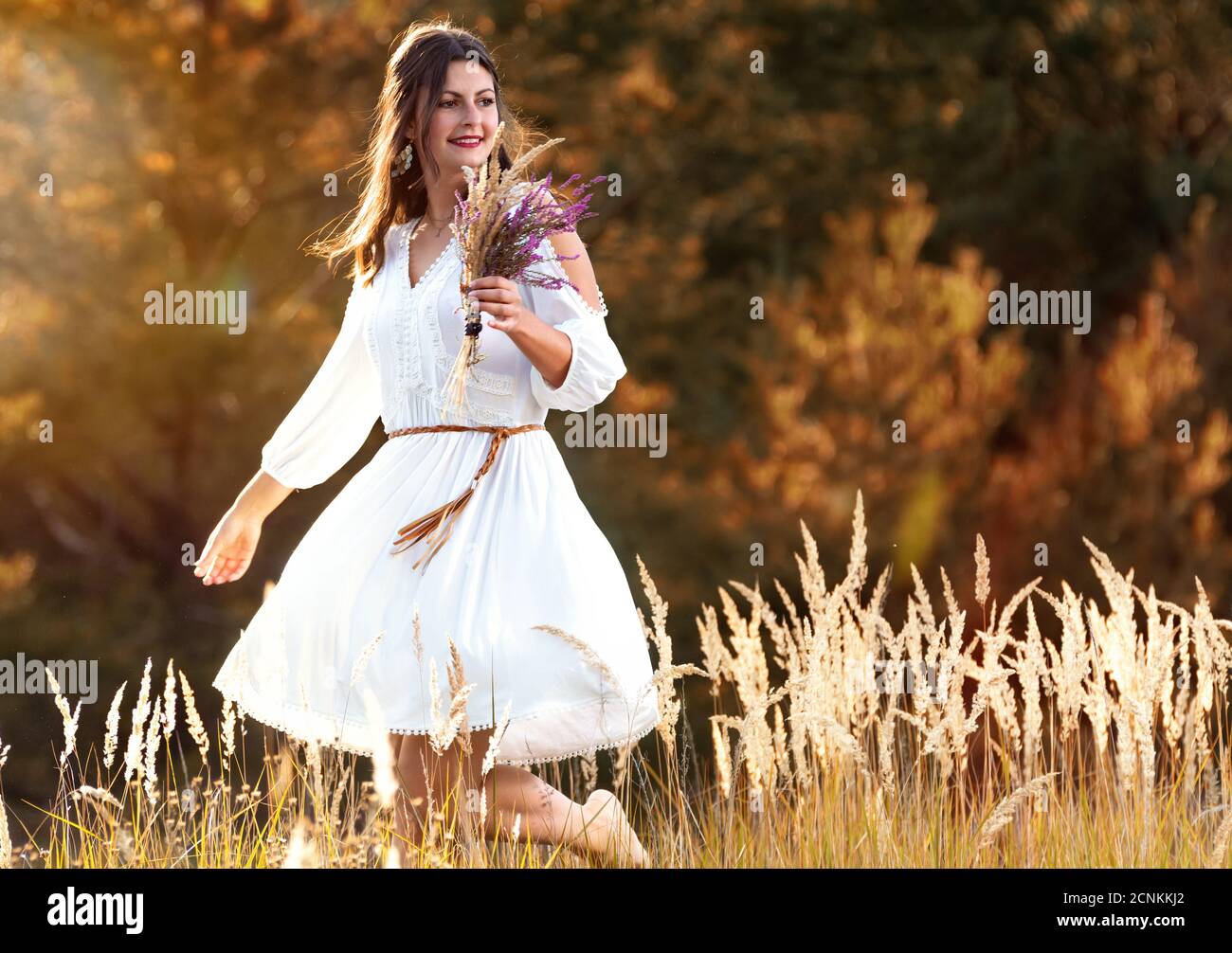 Young woman dancing in the grass and back light Stock Photo