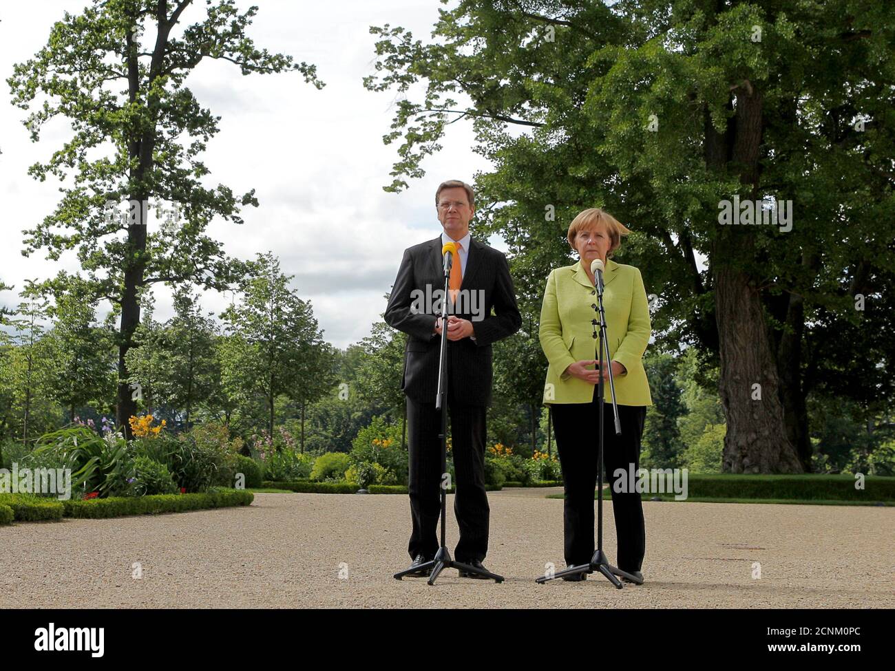 German Chancellor Angela Merkel (R) and Foreign Minister and Vice-Chancellor Guido Westerwelle speak to the media before a meeting with leading representatives of the economy and trade unions at the government guest house Schloss Meseberg, some 70 kilometres (43.5 miles) north of Berlin, June 18, 2010. REUTERS/Thomas Peter  (GERMANY - Tags: POLITICS) Stock Photo