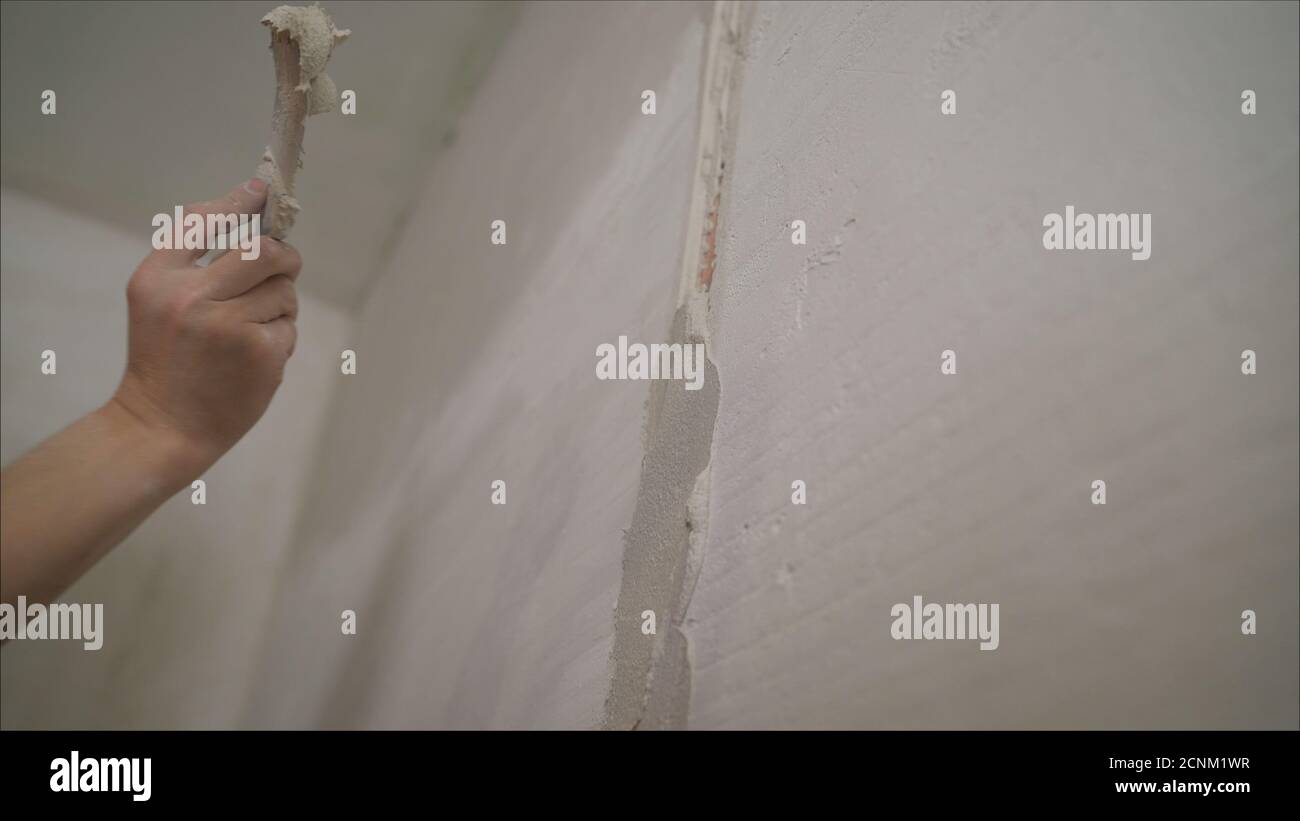 Plasterer putting plaster on wall. Worker covers the wall with mortar