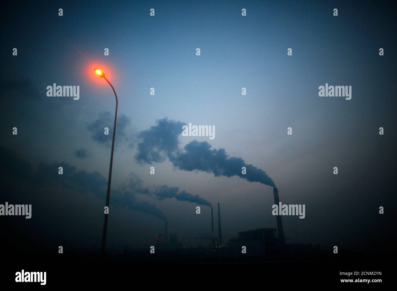 Smoke rises from chimneys of a thermal power plant near Shanghai March 26, 2014. China's energy-hungry, high-polluting industries continued to grow too fast in 2013, putting 'huge pressures' on the environment and causing air quality to worsen, the country's pollution agency said on Tuesday. Premier Li Keqiang 'declared war' on pollution in a major policy address this month, but China has long struggled to strike a balance between protecting the environment and keeping up economic growth.   REUTERS/Carlos Barria (CHINA - Tags: BUSINESS ENVIRONMENT SOCIETY POLITICS) Stock Photo