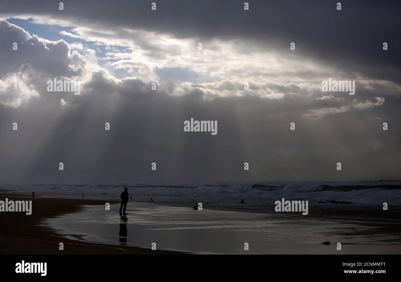A person stands on the shores of the Mediterranean Sea on a stormy day at Nitzanim beach, near the southern city of Ashkelon, January 7, 2013. REUTERS/Amir Cohen (ISRAEL - Tags: ENVIRONMENT TRAVEL TPX IMAGES OF THE DAY) Stock Photo