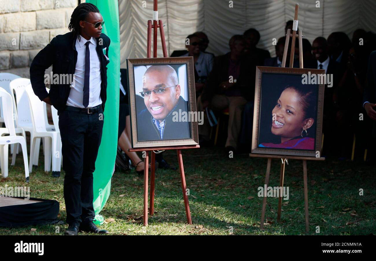 A relative stands next to the portrait photographs of Mbugua Maina and his fiancee Rosemary Wahito, who were both killed during the Westgate Mall shopping mall attack, during their burial in Gatundu village near Nairobi, September 27, 2013. At least 72 people were killed in the attack which occurred over the weekend. REUTERS/Thomas Mukoya (KENYA - Tags: SOCIETY CIVIL UNREST CRIME LAW) Stock Photo