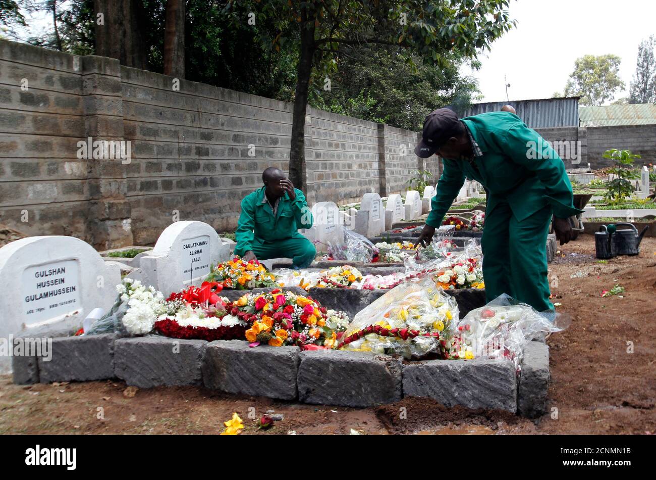 Cemetery workers arrange flowers on the grave of Kenyan journalist Ruhila Adatia Sood, who was killed in the Westgate shopping mall attack, during her funeral in Kenya's capital Nairobi September 26, 2013. U.S., British and Israeli agencies are helping Kenya investigate the attack claimed by Somali Islamist militants on the Nairobi shopping mall that killed at least 72 people and destroyed part of the complex, officials said on Wednesday.   REUTERS/Thomas Mukoya (KENYA - Tags: CIVIL UNREST CRIME LAW) Stock Photo